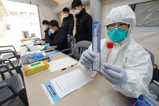 3일 오후 서울 마포구 홍익대학교에 설치된 마포구 선별진료소에서 방호복을 입은 마포구 직원이 검사 키트를 들어 보이고 있다. 2020.3.3 [사진=연합뉴스]