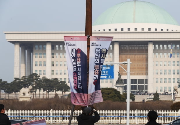 2020년 2월 20일 여의도 국회의사당 앞 가로등에 서울시선거관리위원회 직원들이 '내가 만드는 대한민국, 투표로 시작됩니다' 등의 문구가 적힌 현수기를 게시하고 있다. 사진=연합뉴스