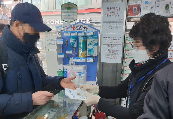 6일 오전 서울 종로구의 한 약국에서 손님이 신분증을 보여주고 마스크를 구입하고 있다. 사진=연합뉴스