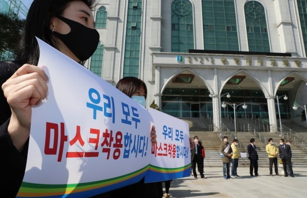 지난 8일 한 교회 앞에서 공무원들이 예배 자제와 마스크 착용을 당부하는 팻말을 들고 있다. 사진=연합뉴스