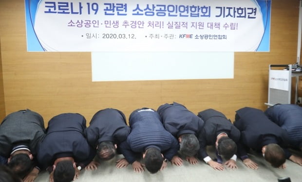 12일 서울 동작구 소상공인연합회에서 열린 코로나19 소상공인 피해 사례 관련 긴급 기자회견에서 참석자들이 생존권 보장을 촉구하며 큰절을 하고 있다. 사진=연합뉴스