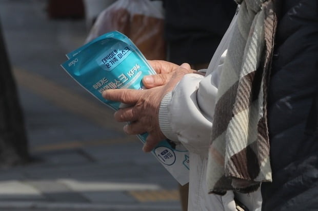21일 오전 서울 종로구 한 약국 앞에서 시민이 구입한 마스크를 손에 쥐고 있다. /사진=연합뉴스