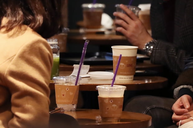 코로나19 감염 우려로 정부는 매장 내 1회용컵 사용 규제를 한시적으로 풀었다. 서울의 한 카페 안에서 소비자들이 1회용컵을 사용하고 있다.  /한경DB
