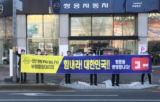 쌍용차 판매네트워크 대표와 직원들이 “코로나19 극복, 힘내자 대한민국” 구호를 외치고 있다. 사진=쌍용차