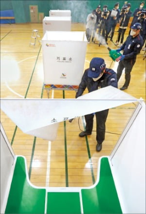 < 투표소 방역 > 제21대 국회의원 총선거를 하루 앞둔 14일 방역 관계자들이 서울 청운동 제1투표소에서 방역작업을 하고 있다.  허문찬 기자 sweat@hankyung.com 