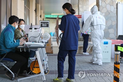 코로나19 경증환자들, 야외서 가운·장갑 착용 후 사전투표