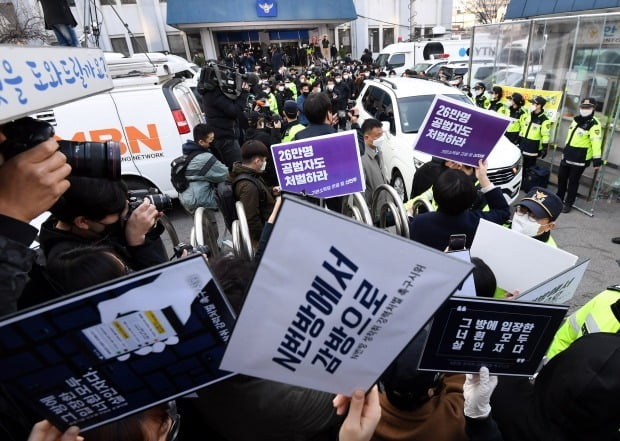 지난달 25일 인터넷 메신저 텔레그램에서 미성년자를 포함한 여성들의 성 착취물을 제작 및 유포한 혐의를 받는 '박사방' 운영자 조주빈이 탄 차량이 서울 종로경찰서를 나와 검찰 유치장으로 향하자 시민들이 조주빈의 강력처벌을 촉구하며 피켓 시위를 하고 있다. 사진=연합뉴스