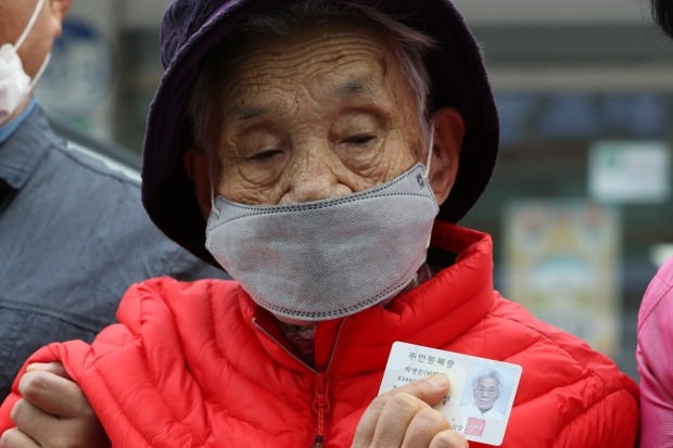 제21대 국회의원 선거일인 15일 오전 광주 북구 문흥1동 행정복지센터에 마련된 투표소 앞에서 박명순 할머니가 