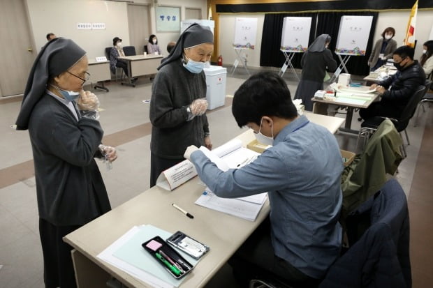 제21대 국회의원 선거일인 15일 오전 서울 중구 명동주민센터에 마련된 명동 제1투표소를 찾은 수녀들이 투표하기 위해 본인확인을 하고 있다./ 사진=뉴스1