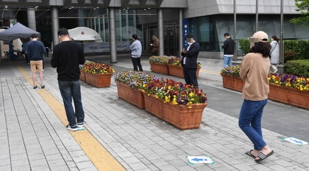 10일 오후 서울 용산구보건소 선별진료소에서 검사를 원하는 시민들이 2m 간격을 유지한 채 순서를 기다리고 있다. 이태원동 일대 클럽에서 발생한 집단 감염 등으로 하루 동안 확진 환자가 34명 늘었다. 하루 신규 환자가 30명 넘은 건 4월12일 32명 이후 28일 만이다./김범준기자bjk07@hankyung.com