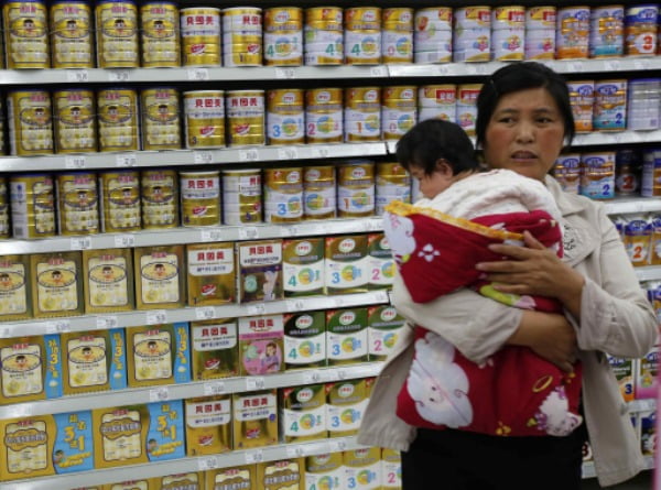 2013년 분유 파동 당시 중국 베이징의 한 슈퍼마켓에서 아기를 안은 한 엄마가 근심 어린 표정으로 분유 매장을 살피고 있다. /사진=연합뉴스