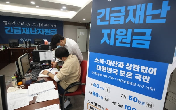 지난 12일 서울 성북구청에서 직원들이 긴급재난지원금 신청과 관련해 안내, 상담을 하고 있다.  연합뉴스