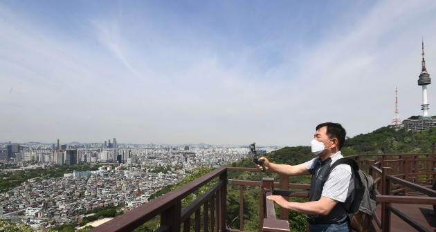 맑은 날씨를 보인 21일 오전 남산서울타워로 산책나온 한 시민이 청명한 하늘을 카메라에 담고 있다./김범준기자 bjk07@hankyung.com