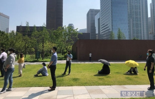 서소문 임시 선별진료소를 찾은 시민들이 거리를 유지한 채 검사를 기다리고 있다. 대기 시간이 길어지자 일부 시민들은 우산을 쓰며 더위를 피하기도 했다. 사진=김민성 한경닷컴 기자