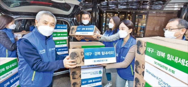 SC제일은행은 지난 3월 마스크 5000장을 대구동산병원에 기부했다. 박종복 행장(왼쪽 두 번째)과 임직원이 의료진에 지원하기 위한 마스크를 차량에 싣고 있다.  SC제일은행 제공

 