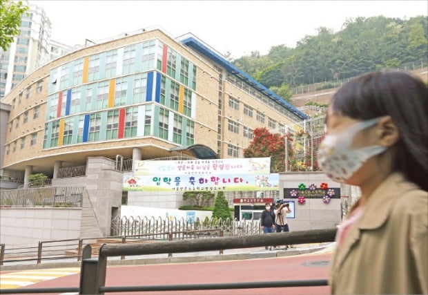 < 굳게 닫힌 교문 >  학생 한 명이 26일 코로나19 확진 판정을 받은 서울 응암동 연은초 정문이 굳게 닫혀 있다. 연은초는 다음날 예정된 1~2학년 등교를 연기했다.  뉴스1 