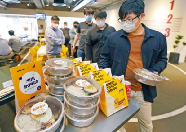 지난 26일 서울 역삼동의 한 스타트업 직원들이 점심시간에 사무실로 배달된 신세계푸드의 ‘셰프투고’ 메뉴를 골라담고 있다.  신세계푸드 제공 