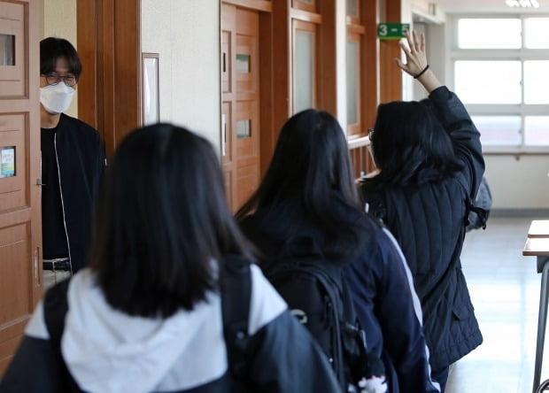 20일 오전 대구시 중구 경북여자고등학교에서 신종 코로나바이러스 감염증(코로나19)으로 개학이 80일 미뤄졌다가 이날 등교한 고3 학생이 선생님에게 손을 들어 인사하고 있다./ 사진=연합뉴스