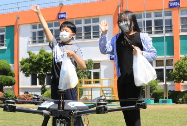 8일 오전 해안초등학교 학생들이 0.8㎞를 날아 간식을 배달한 드론을 반기고 있다. /사진=연합뉴스