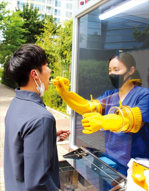 안여현 부산 남구보건소 사무관이 지난 1일 부산 대연동 남구보건소 뒷마당에 설치된 워크스루형 코로나19 검사장비 안에서 검체 채취를 시연하고 있다.  노경목 기자 