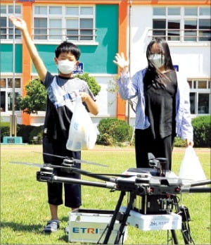 제주 해안초교 학생들이 드론으로 ‘펭수 샌드위치’를 배달받고 기뻐하고 있다.  GS리테일 제공 