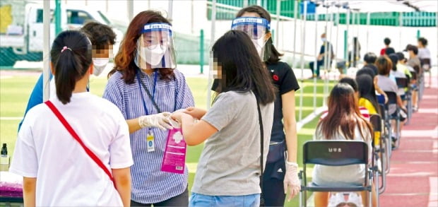 < 초등학교 긴급 검사 > 보건당국 관계자가 28일 서울 관악구 난우초등학교에 설치된 이동 선별진료소에서 학생, 교사, 교직원을 대상으로 신종 코로나바이러스 감염증 검사를 하고 있다. 이 학교 시간강사 한 명이 집단감염이 발생한 왕성교회에서 감염됐다.   김영우 기자 youngwoo@hankyung.com 