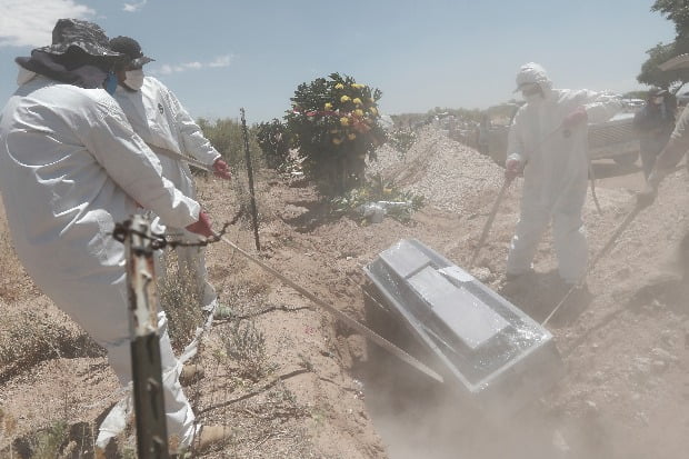 멕시코의 코로나19 사망자 묘역에서 19일(현지시간) 보호복을 착용한 작업자들이 관을 묻고 있다. / 사진=AP
