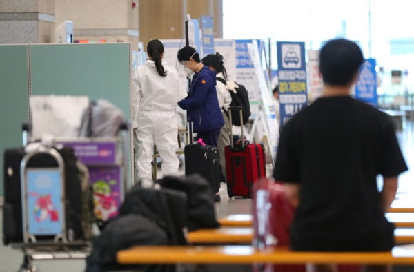 인천국제공항에서 관계자들이 해외 입국자들을 안내하는 모습. 연합뉴스