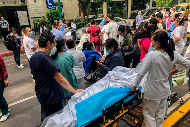 23일(현지시간) 멕시코 남부 오악사카주 연안에서 강진이 발생한 이후 진동에 놀란 수도 멕시코시티의 한 병원 의료진과 환자들이 밖으로 대피해 있다.  사진=연합뉴스