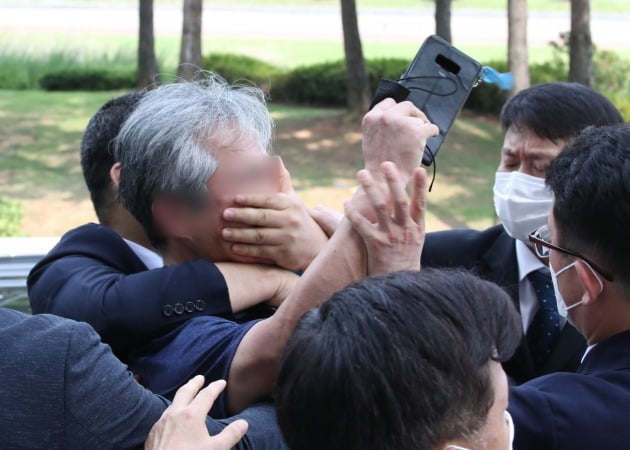 대통령 경호원들이 16일 오후 서울 여의도 국회에서 열린 제21대 국회 개원식에 참석한 문재인 대통령을 향해 신발을 던지고 소리를 지르는 시민의 입을 막고 있다.2020.7.16 [사진=연합뉴스]