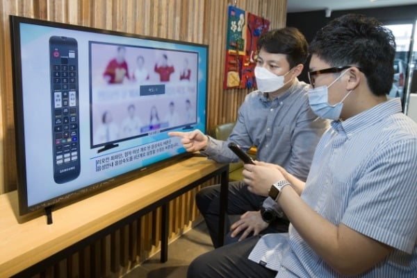 삼성전자 상품전략팀 직원(위)이 서울 관악구에 위치한 실로암 시각장애인 복지관에서 한 시각장애인에게 삼성전자 스마트TV의 접근성 기능에 대해 설명하고 있다/사진제공=삼성전자