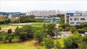 차세대 디스플레이 연구개발 혁신공정센터가 들어설 천안시 직산읍 충남테크노파크 야구장 너머로 아파트 단지가 들어서 있다. 