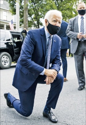 미국 민주당 대선 후보인 조 바이든 전 부통령(왼쪽)이 9일(현지시간) 고향인 펜실베이니아주 스크랜튼에서 어린이들과 눈높이를 맞추기 위해 한쪽 무릎을 꿇고 있다.  AP연합뉴스 