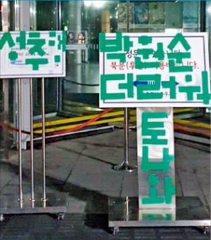 14일 서울시청 정문 앞에 설치된 안내 팻말 위에 고(故) 박원순 서울시장을 비난하는 문구가 붙어 있다.  연합뉴스 