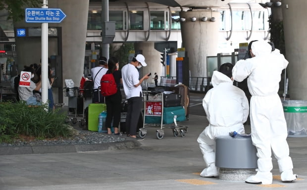  인천국제공항에서 관계자들이 대기 중인 해외입국자들을 바라보고 있다. 사진=연합뉴스