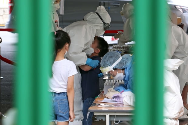 18일 광주 서구 치평동 계수초등학교 주차장에 마련된 이동선별진료소에서 의료진이 울음을 터뜨리는 아이를 달래고 있다. 사진=연합뉴스