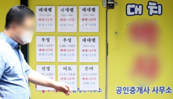지난달 11일 한 시민이 서울 강남구 아파트단지 밀집지역에 위치한 부동산의 매물 정보란 앞을 지나가고 있다. /사진=뉴스1