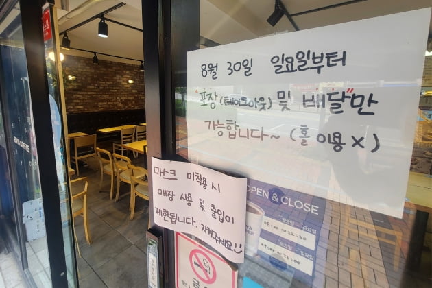 서울의 한 커피전문점 출입문에 오는 30일부터 음료 판매가 포장과 배달만 가능하다는 안내문이 붙어 있다. /사진=뉴스1