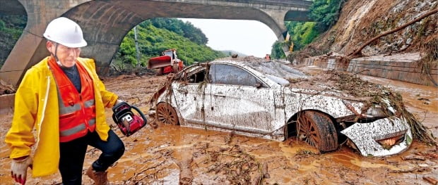 < 여기가 고속도로라니…진흙탕으로 변한 안성 일죽IC 주변 > 2일 중부지방에 시간당 최대 100㎜에 달하는 폭우가 쏟아지면서 산사태로 도로가 막히는 사고가 잇따랐다. 경기 안성시 중부고속도로 일죽IC 인근에서 발생한 산사태로 차량이 파손된 채 도로 한가운데 서 있다.   안성=김범준 기자 bjk07@hankyung.com 