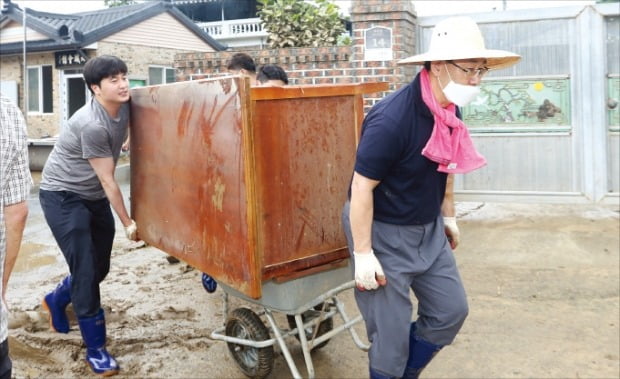 < 리어카 끄는 주호영 > 주호영 미래통합당 원내대표(오른쪽)가 11일 전남 구례 구성마을에서 침수 피해 폐기물을 옮기고 있다.  연합뉴스 