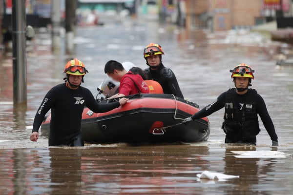 전남 구례군 구례읍 도심이 폭우로 잠기자 구조대가 고무보트를 타고 고립된 주민을 구조하고 있는 모습. 연합뉴스