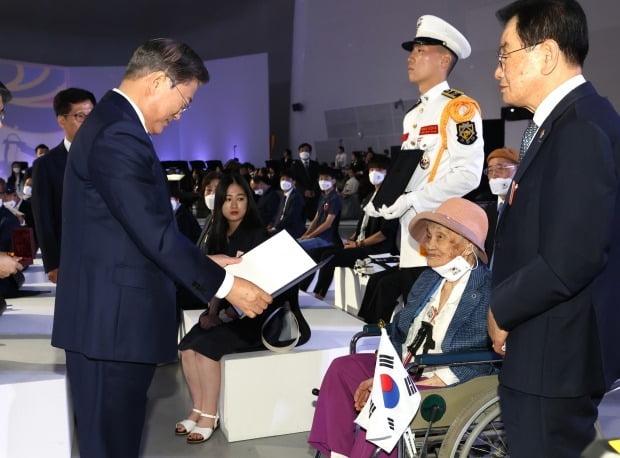 문재인 대통령이 15일 오전 서울 동대문디자인플라자에서 열린 제75주년 광복절 경축식에서 독립유공자 고 최사진 씨의 배우자 박명순 씨에게 대통령 표창을 수여하고 있다(사진=연합뉴스)