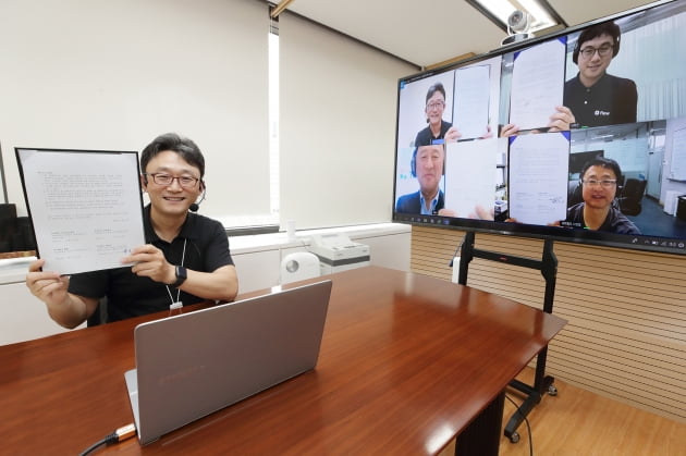 박윤영 KT 기업부문 사장이 서울 광화문 KT 빌딩에서 디배면으로 국내 강소기업 대표들과 업무협약을 체결하고 있다. KT 제공