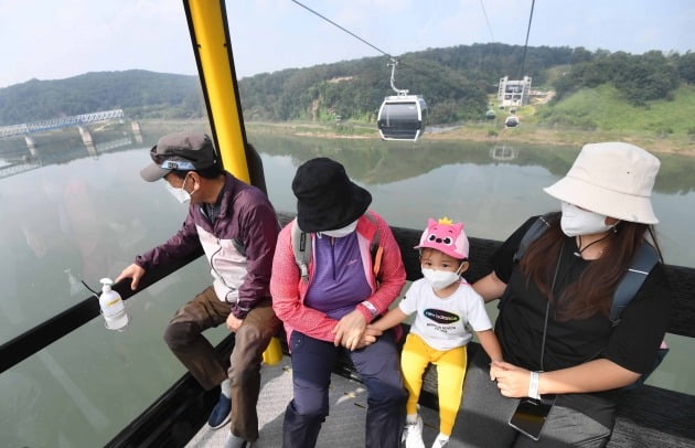  15일 임진각을 찾은 한 가족이 평화 곤돌라를 타고 임진각 북쪽으로 향하면서 한국 전쟁 때 폭파돼 교각만 남아 있는 경의선철교 독개다리를 바라보고 있다.김범준기자 bjk07@hankyung.com