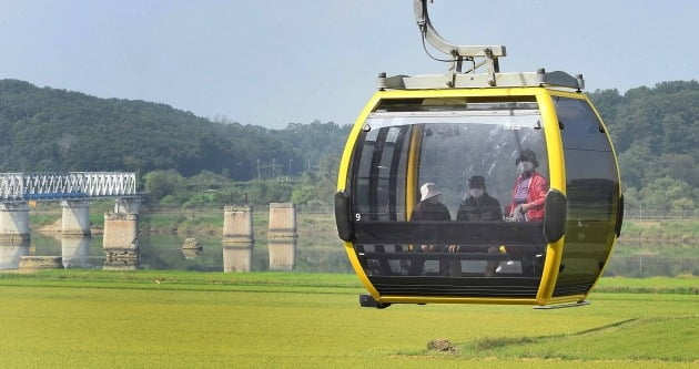  15일 임진각을 찾은 한 가족이 평화 곤돌라를 타고 임진각 북쪽으로 향하면서 한국 전쟁 때 폭파돼 교각만 남아 있는 경의선철교 독개다리를 지나고 있다./김범준기자 bjk07@hankyung.com