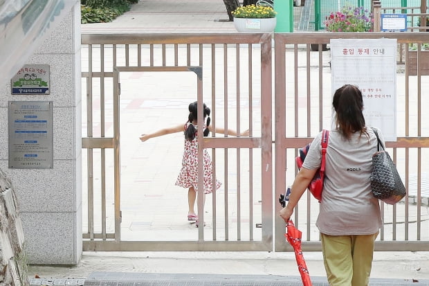 서울의 한 초등학교에서 어머니가 자녀를 오후 돌봄교실에 바래다주고 있다. 사진=뉴스1