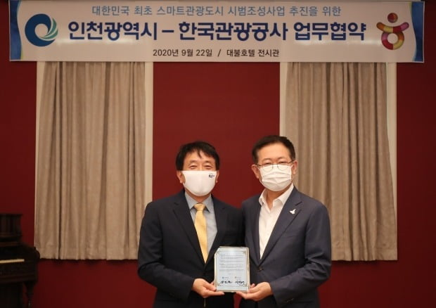 한국관광공사와 인천광역시가 인천 중구 개항장 일원에 스마트관광도시를 조성한다. 내년 상반기까지 총 88억원의 예산을 투입해 스마트관광 환경을 구축하는 사업이다. 22일 인천 송도 대불호텔에서 스마트관광도시 시범조성사업 추진을 위한 협약을 맺은 박남춘 인천광역시장(사진 오른쪽)과 안영배 한국관광공사 사장이 전자 협약서에 서명한 후 기념사진을 찍고 있다. / 한국관광공사 제공.  