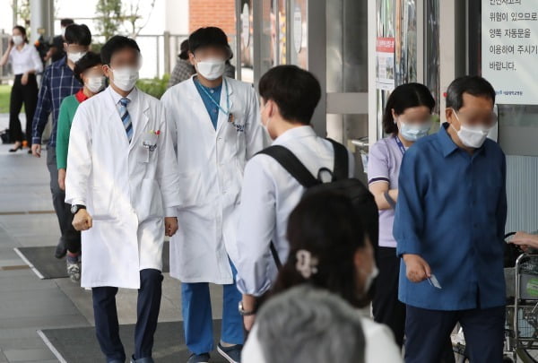 전공의들이 집단휴진을 벌인 지 18일 만에 업무에 복귀한 8일 서울 종로구 서울대학교병원에서 의료진이 이동하고 있다. 연합뉴스