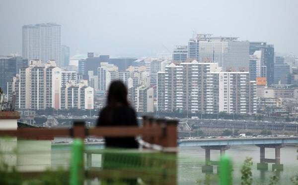 한 시민이 서울 한강변에서 건너편 아파트 단지를 바라보고 있다. 연합뉴스