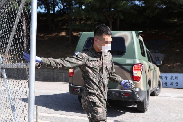  5일 경기도 포천시의 한 육군 부대에서 군 관계자가 마스크와 장갑을 착용한 채 문을 닫고 있다. 이 부대에서 신종 코로나바이러스 감염증(코로나19) 확진자가 무더기로 발생해 군 당국이 포천 지역 전 부대 외출을 통제했다. 2020.10.5 [사진=연합뉴스]